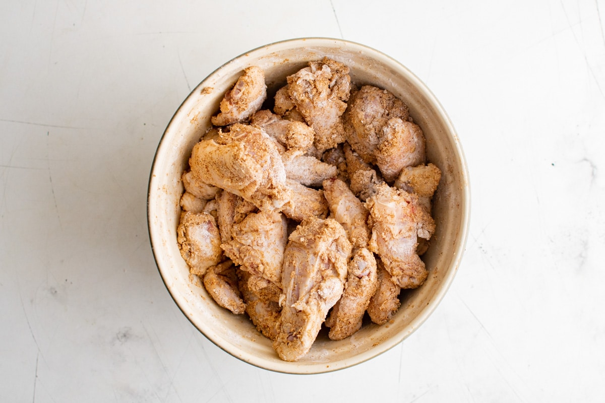 seasoned and floured chicken wings in a bowl