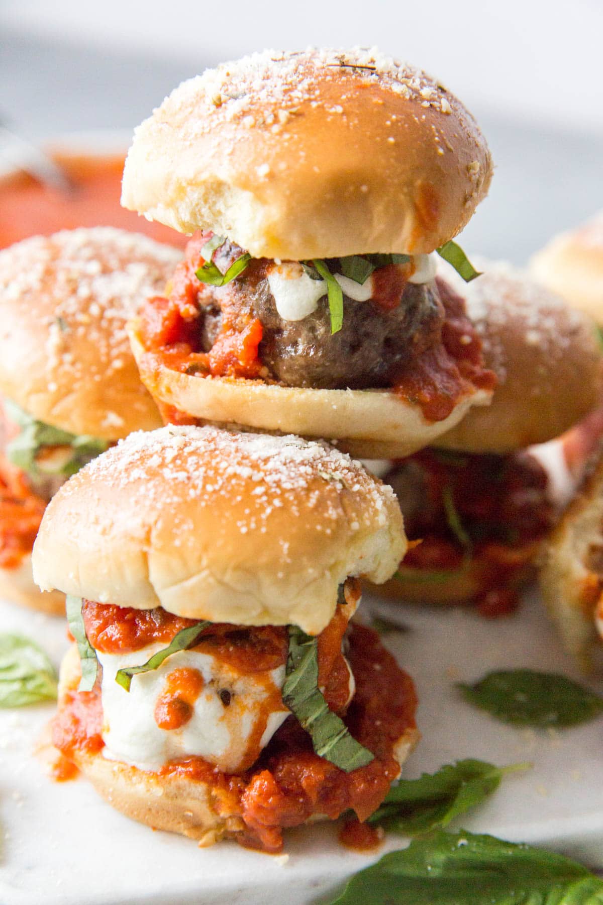 stack of meatball sliders with sauce and basil