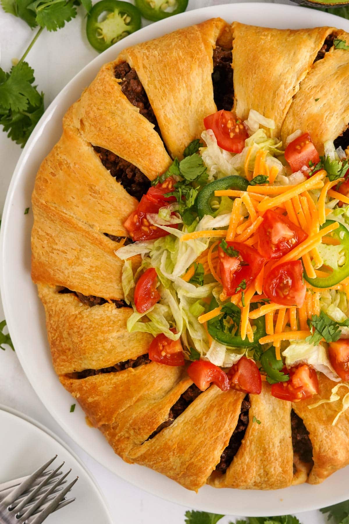 close up overhead of taco ring with lettuce, tomatoes, cheese