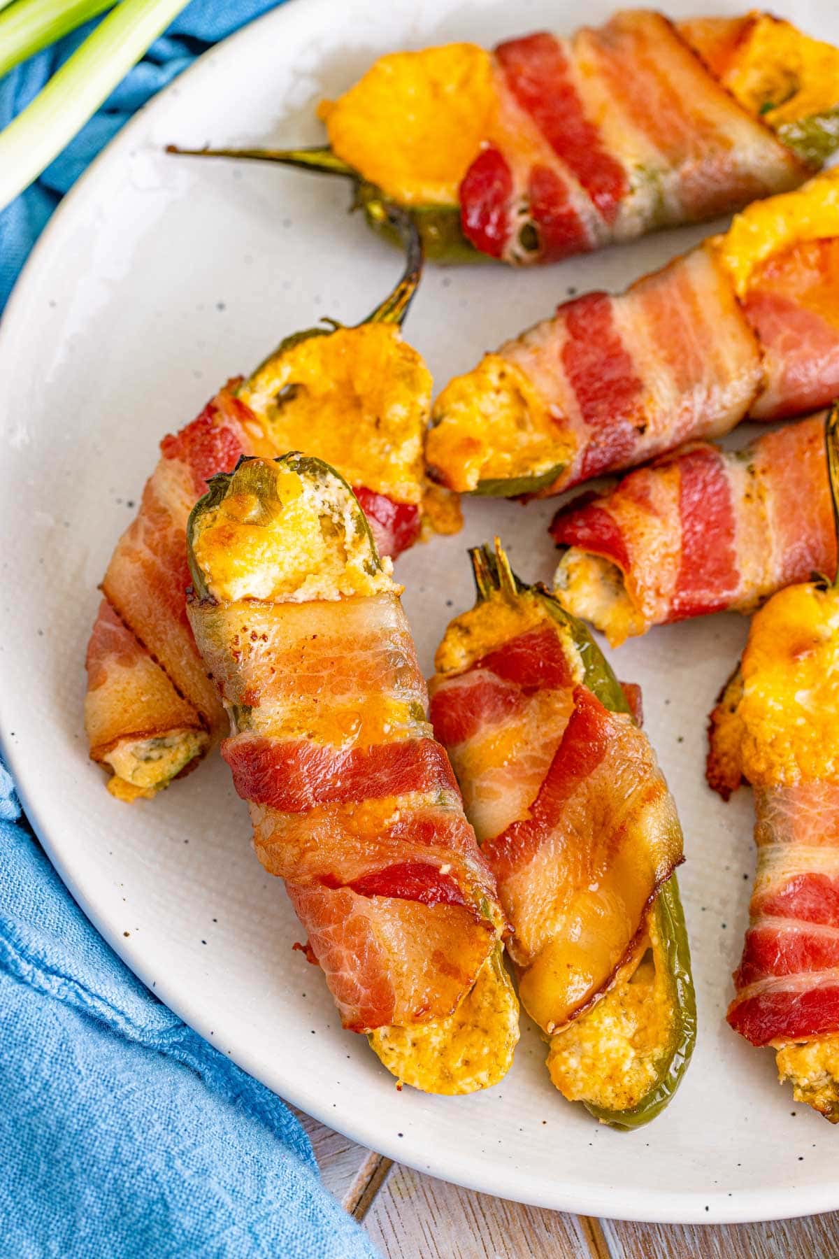 jalapeno poppers with bacon sitting on a white plate