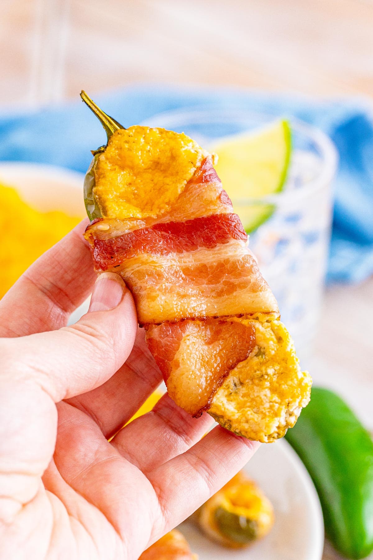 a large bacon wrapped jalapeno popper in someone's hand