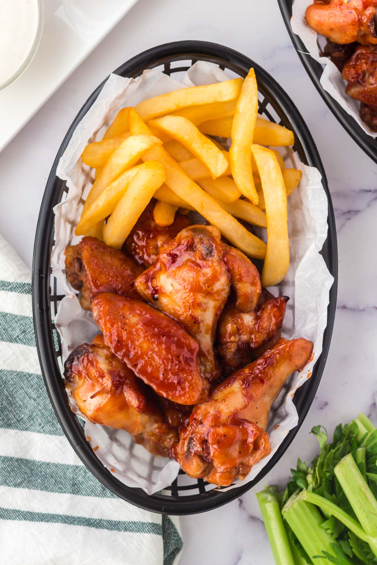 bbq chicken wings in a basket with fries