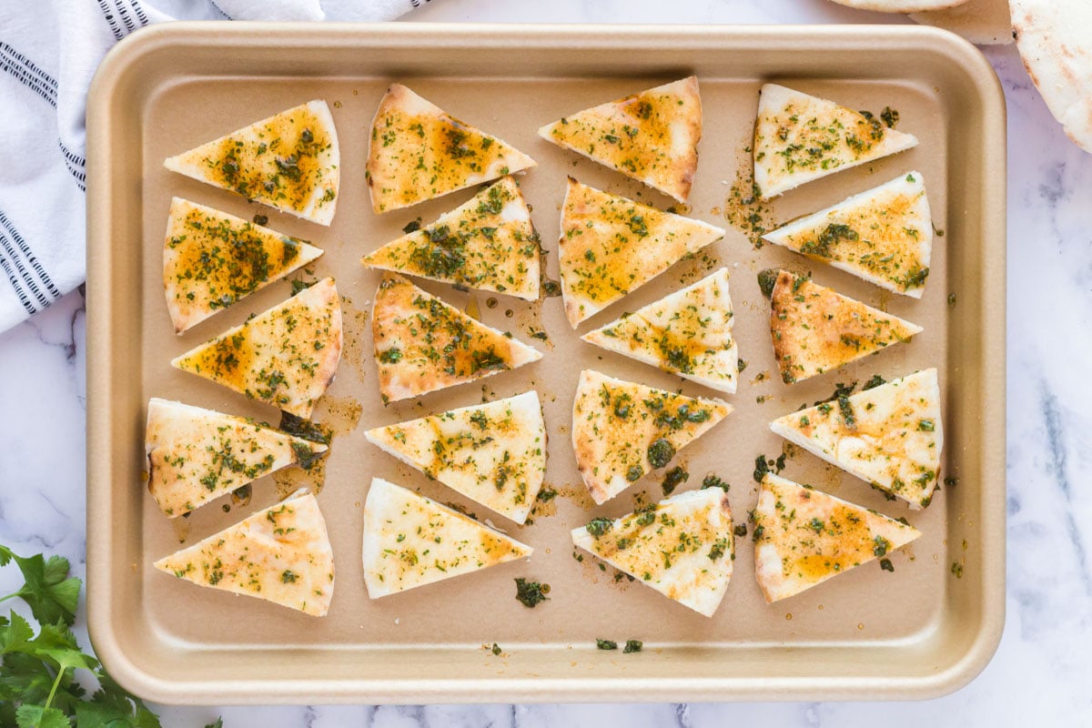 seasoned pita bread on a baking sheet