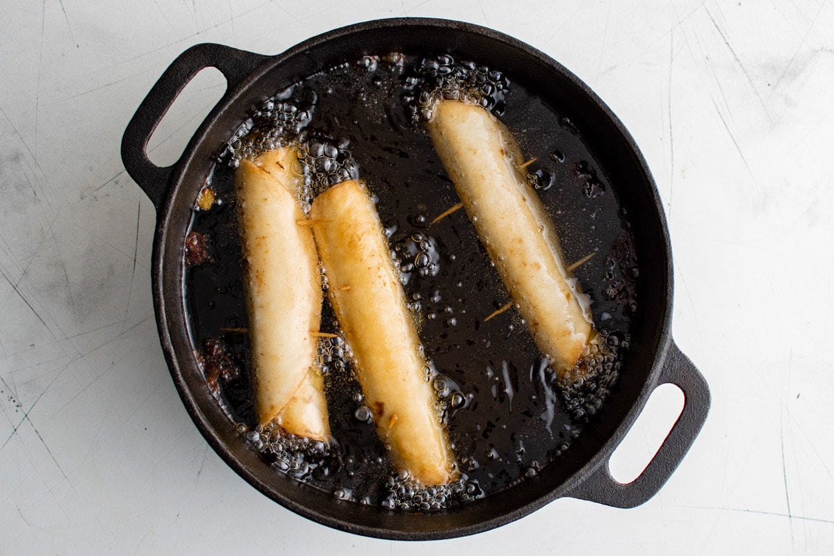 flautas cooking in hot oil in a skillet