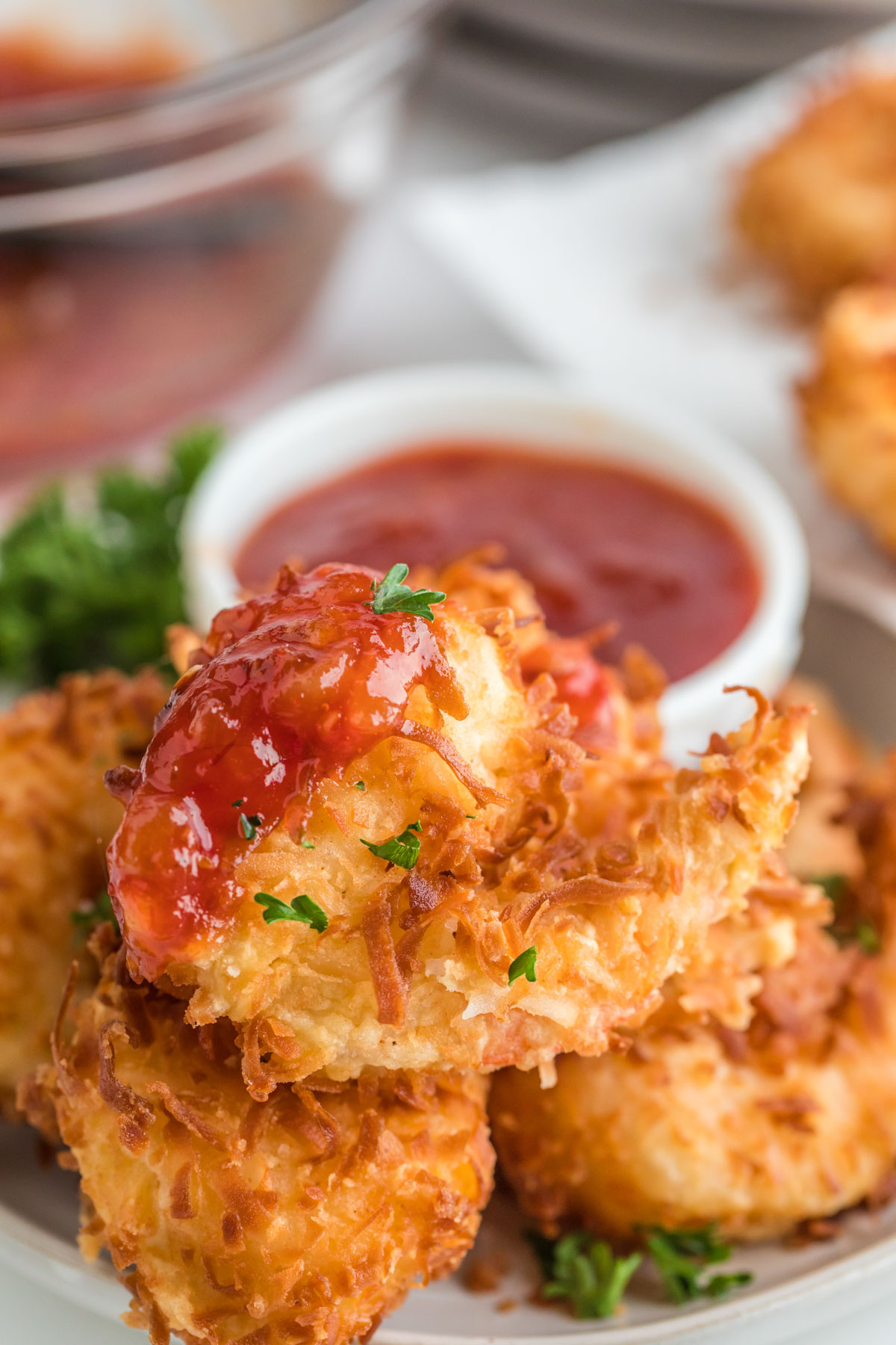 coconut shrimp on. aplatter with a dish of a red sauce.