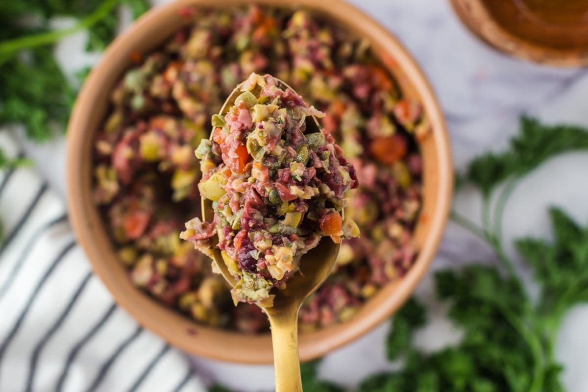 close up image of a spoon with olive tapenade mixture