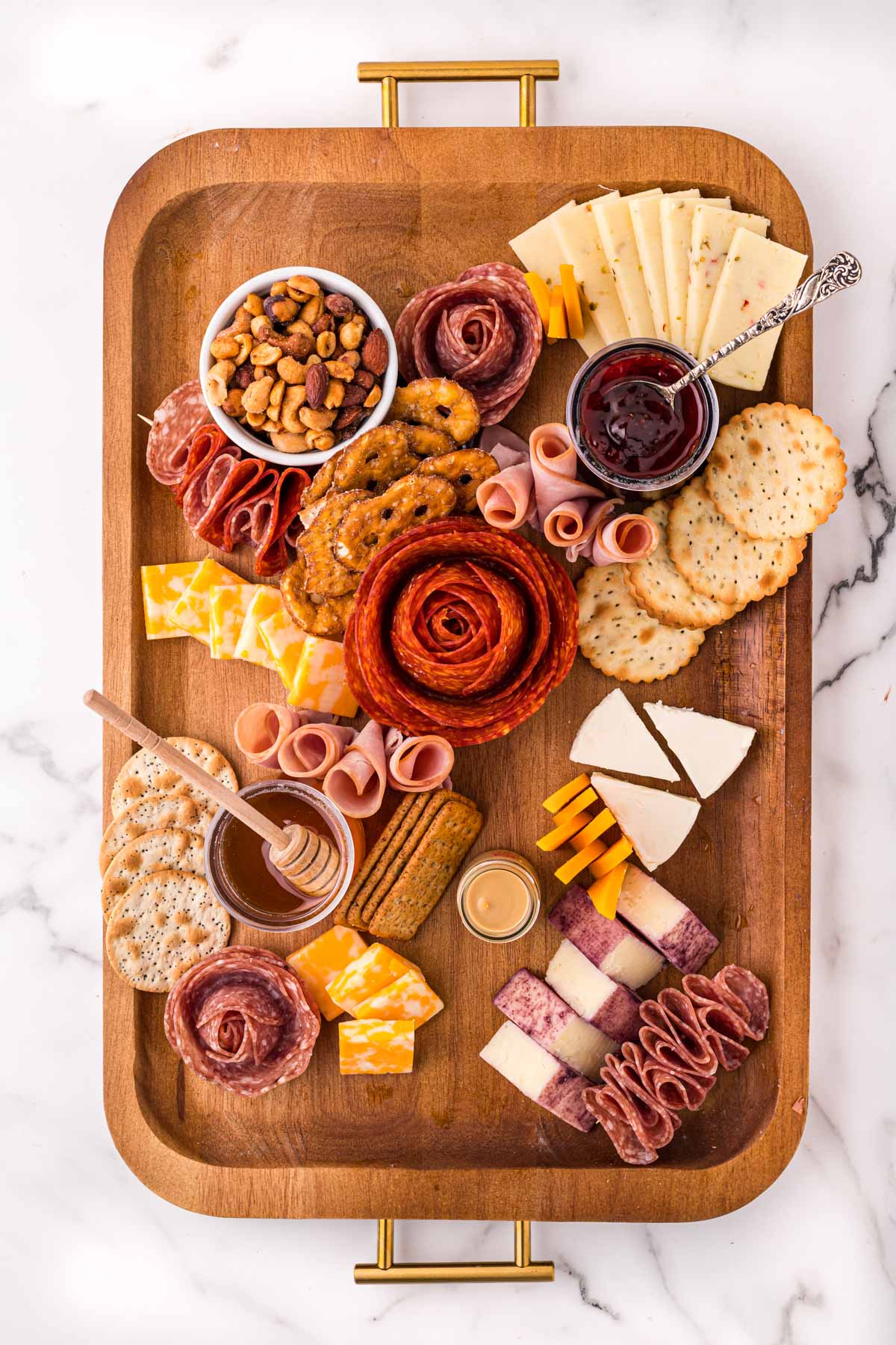adding crackers to meat and cheese board