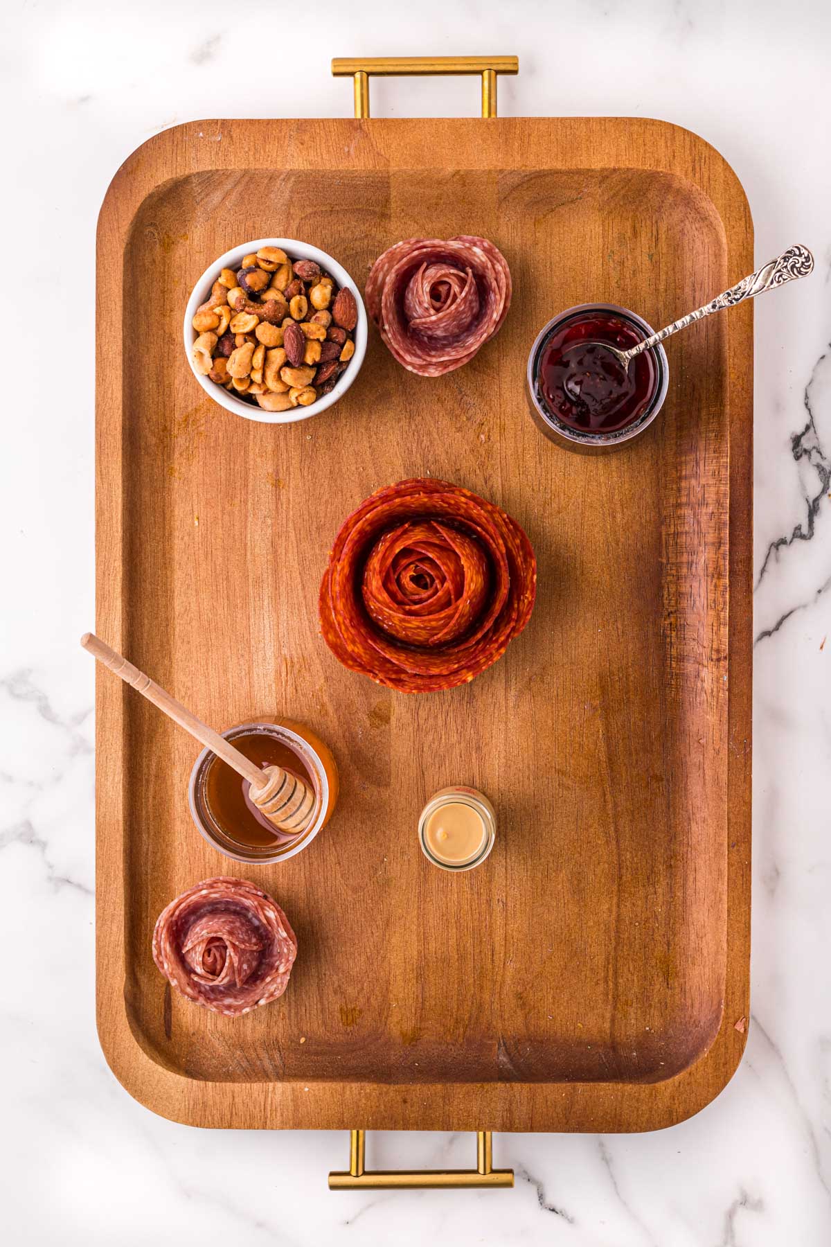 wood board with dishes of condiments and meat roses