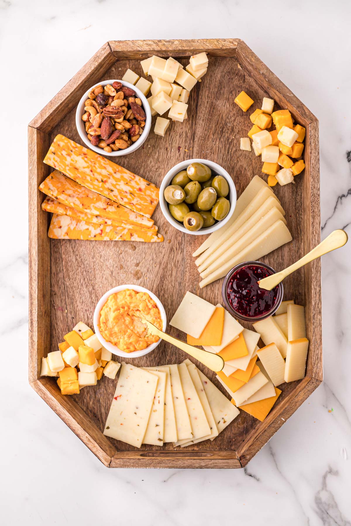 wood tray with variety of cheeses, and dishes of condiments