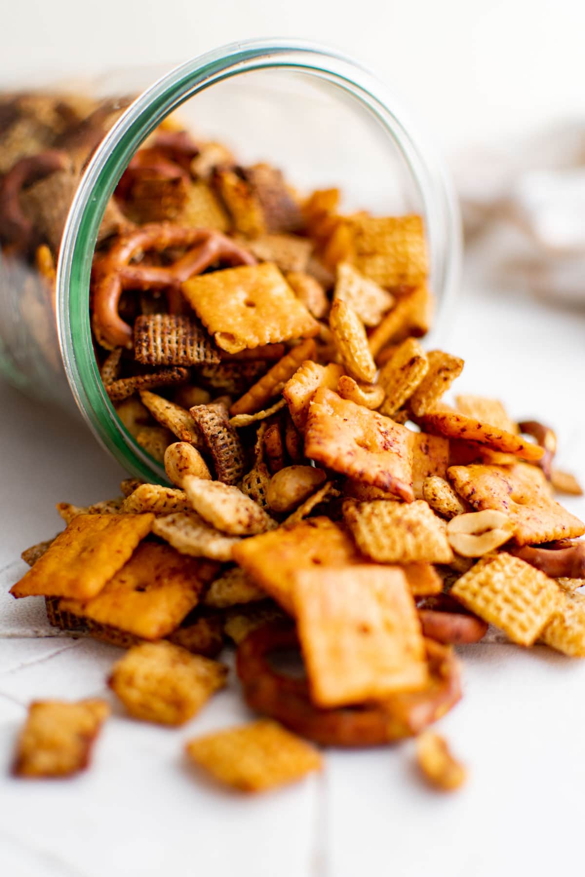 spicy chex mix spilling out from a glass