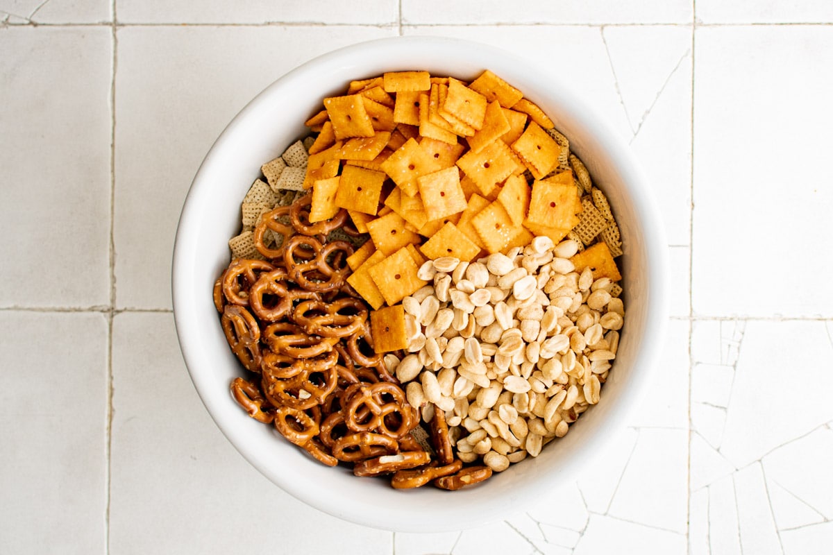 white bowl with cheese-its, chex cereal peanuts and pretzels