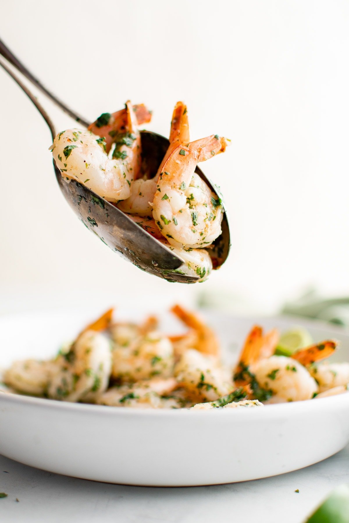 Shrimp with cilantro and lime with serving spoons. 