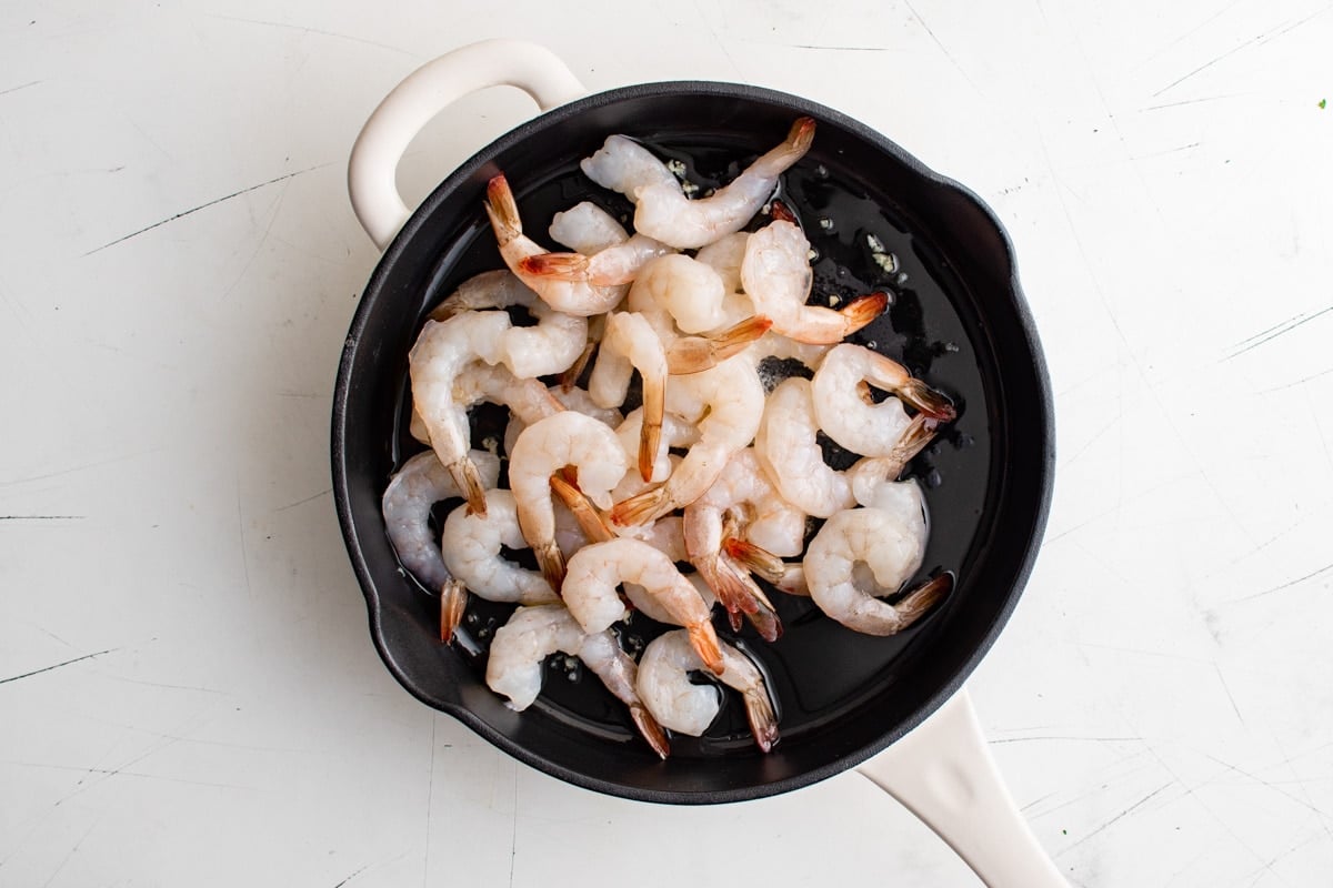 Large tail-on shrimp in a skillet. 