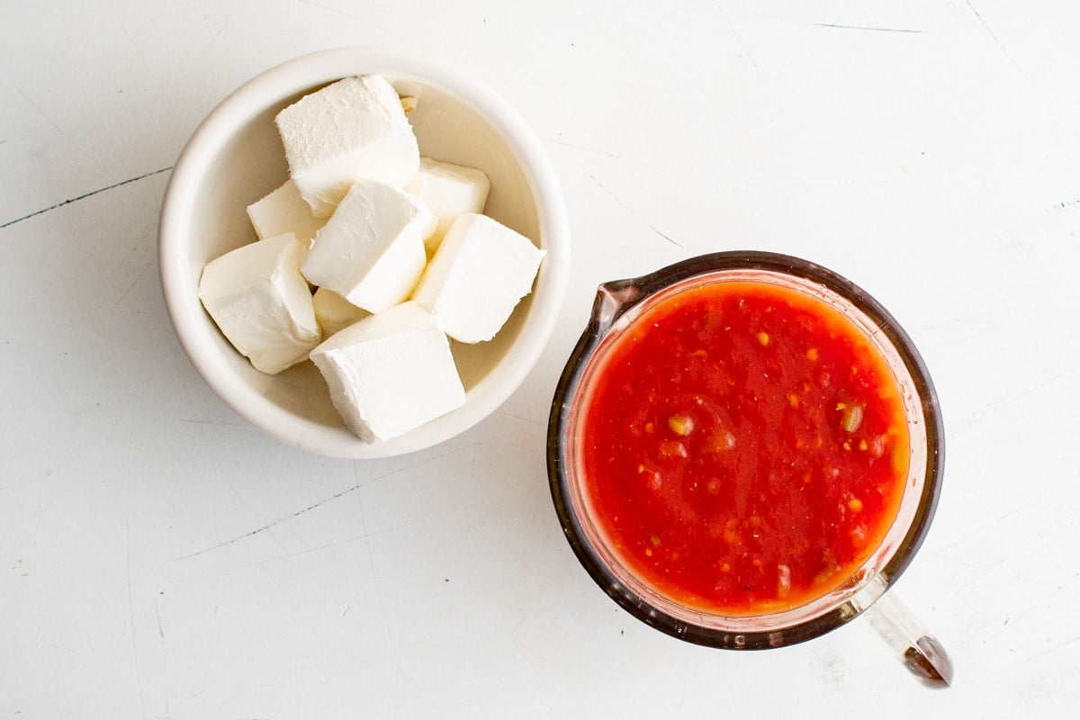 blocks of cream cheese in a white bowl, salsa in a white bowl.