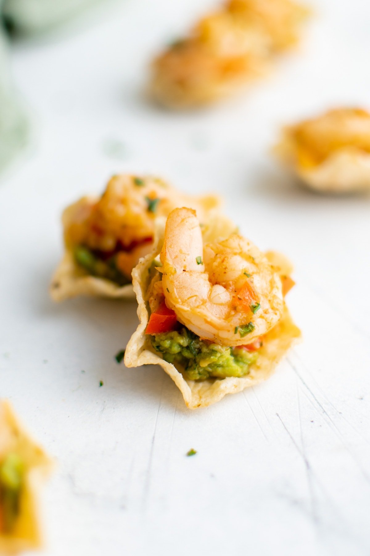 A couple of taco scoops with shrimp and guacamole.