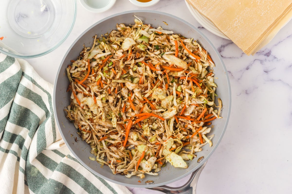 Cooked cabbage and carrots in a skillet.