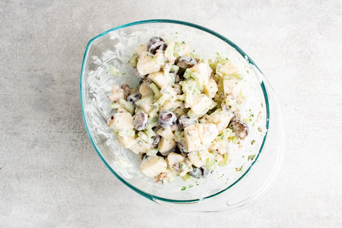 A clear glass bowl with a yogurt dressed Waldork Salad. 