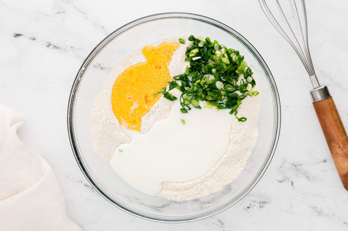 Bowl with flour, cornmeal and green onions. 