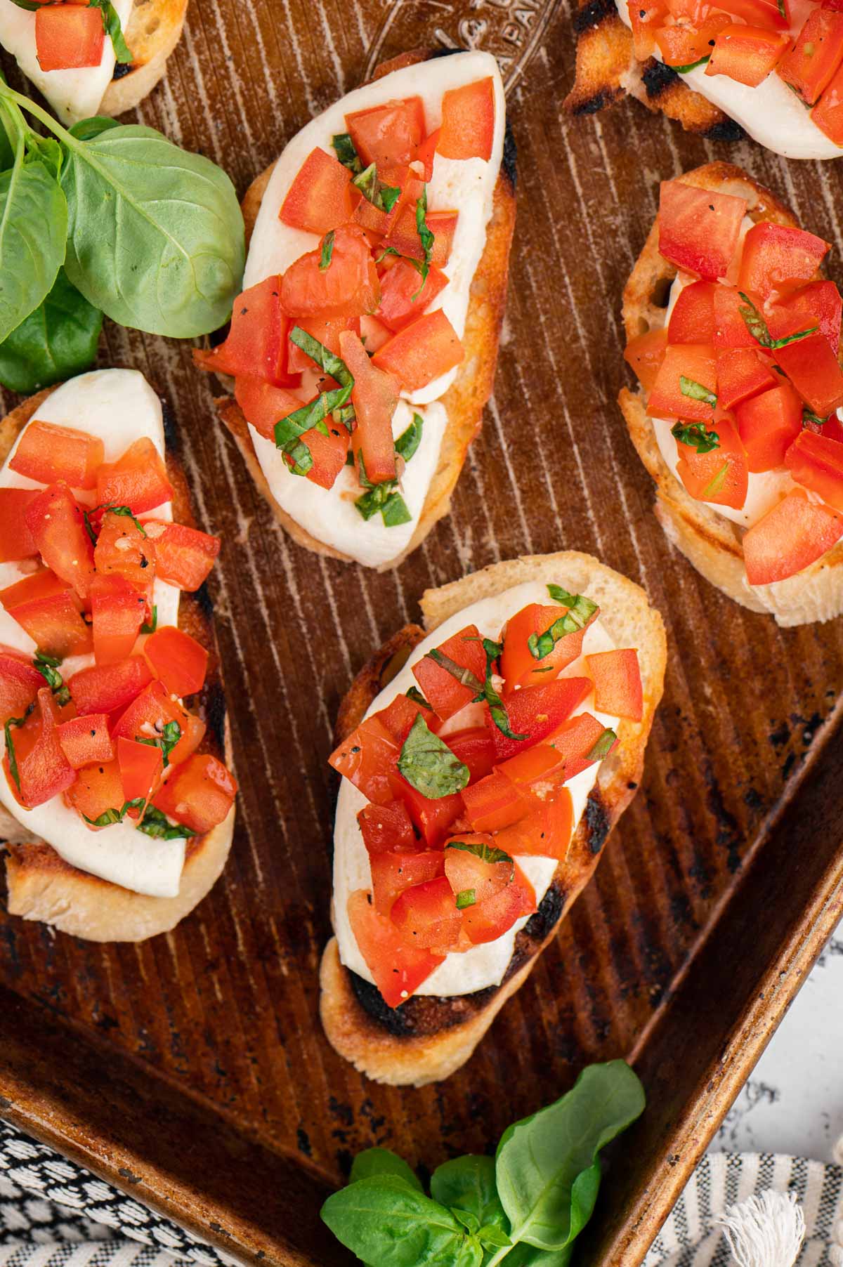 Baking sheet with toasted bread with tomato bruschetta.