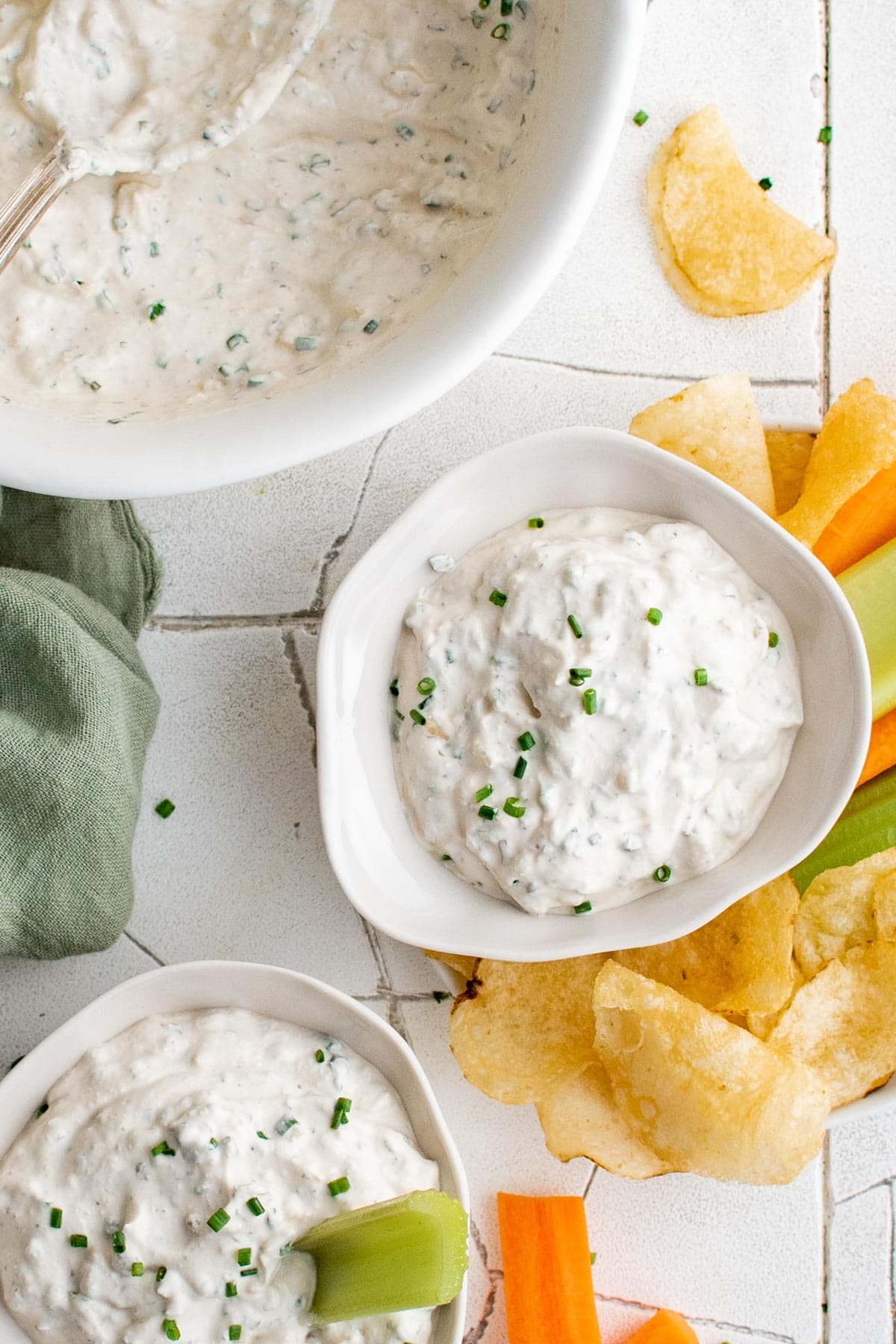 Small bowls of onion dip with chips and veggies. 