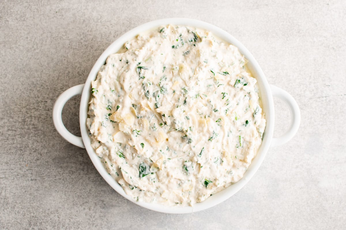 Unbaked Crab spinach dip in a baking dish. 
