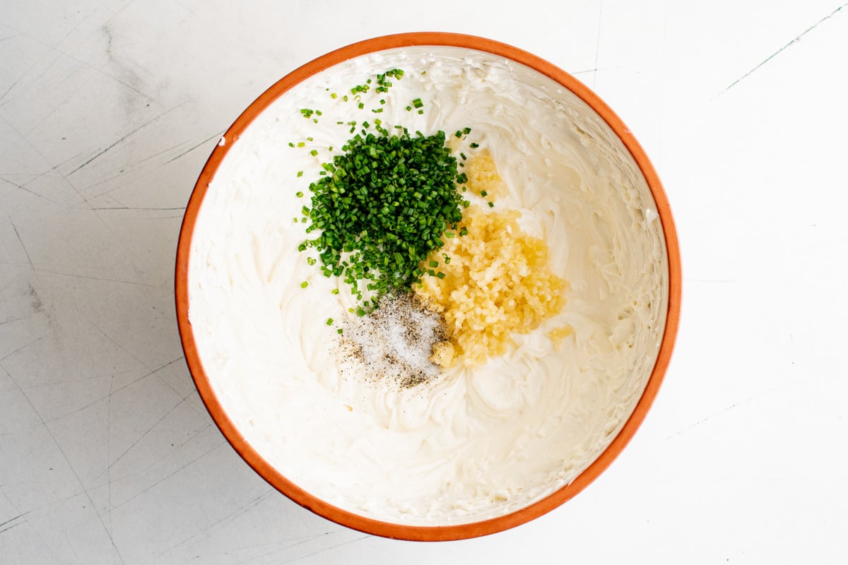 bowl with cream cheese and fresh herbs.