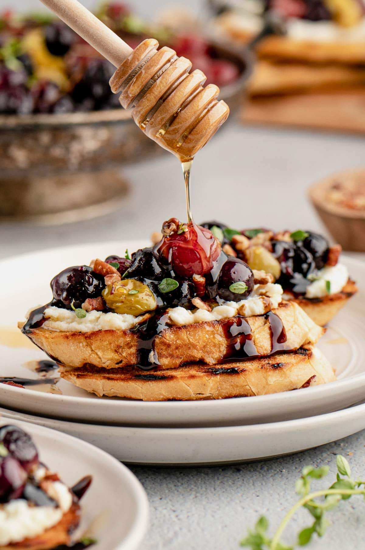 Toasted crostini with ricotta cheese spread and roasted grapes and honey.