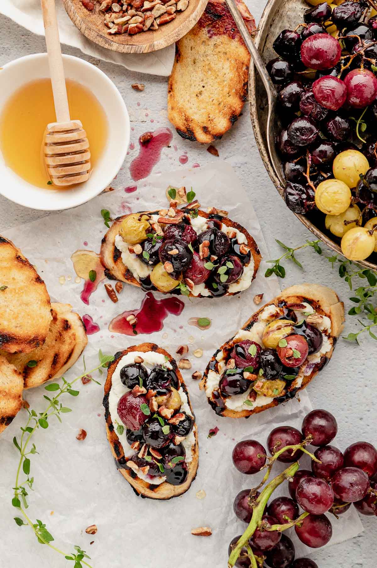 Crostini toasts with ricotta cheese and roasted grapes.