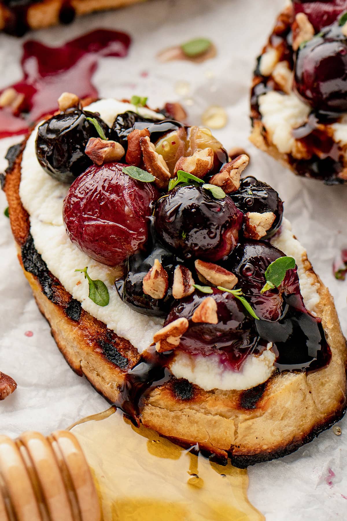 Toasted bread with cheese, roasted grapes, thyme and pecans.