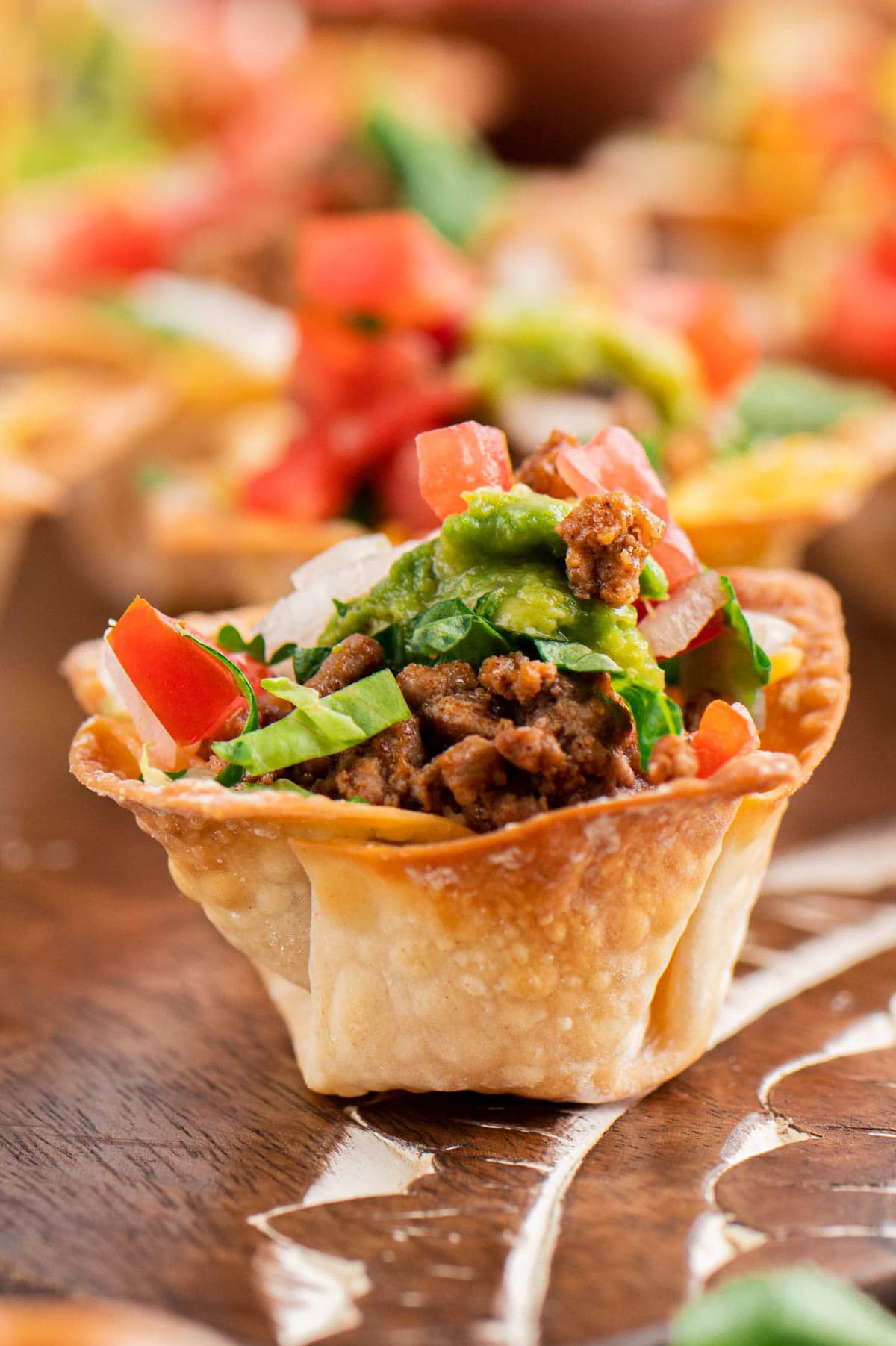 Wonton cup filled with taco meat, cheese and lettuce
