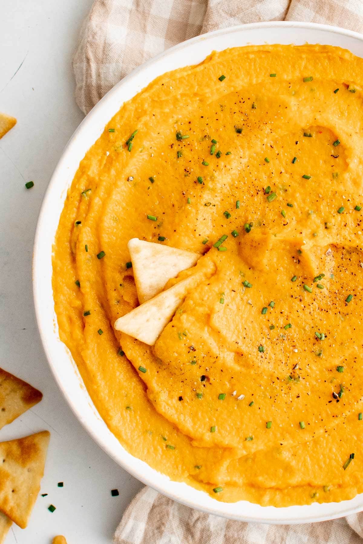 Large bowl of sweet potato dip with 2 pita chips