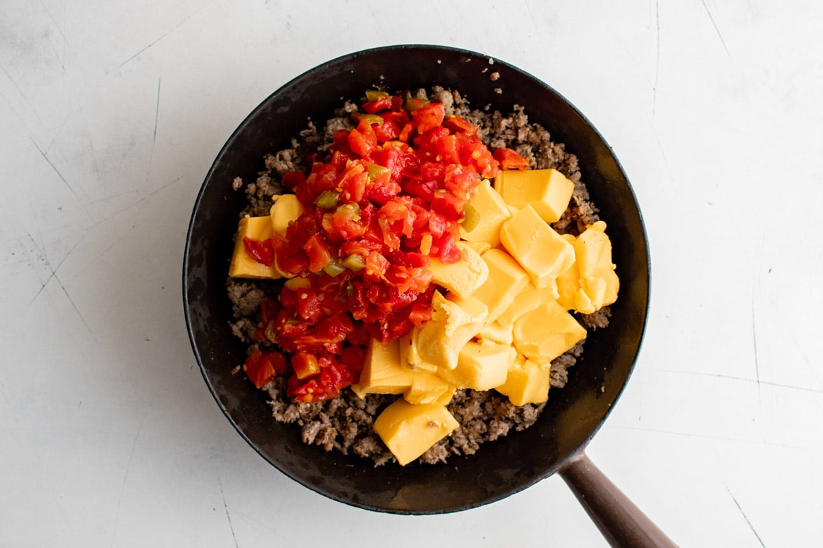 Ground sausage, canned tomatoes and Velveeta in a skillet